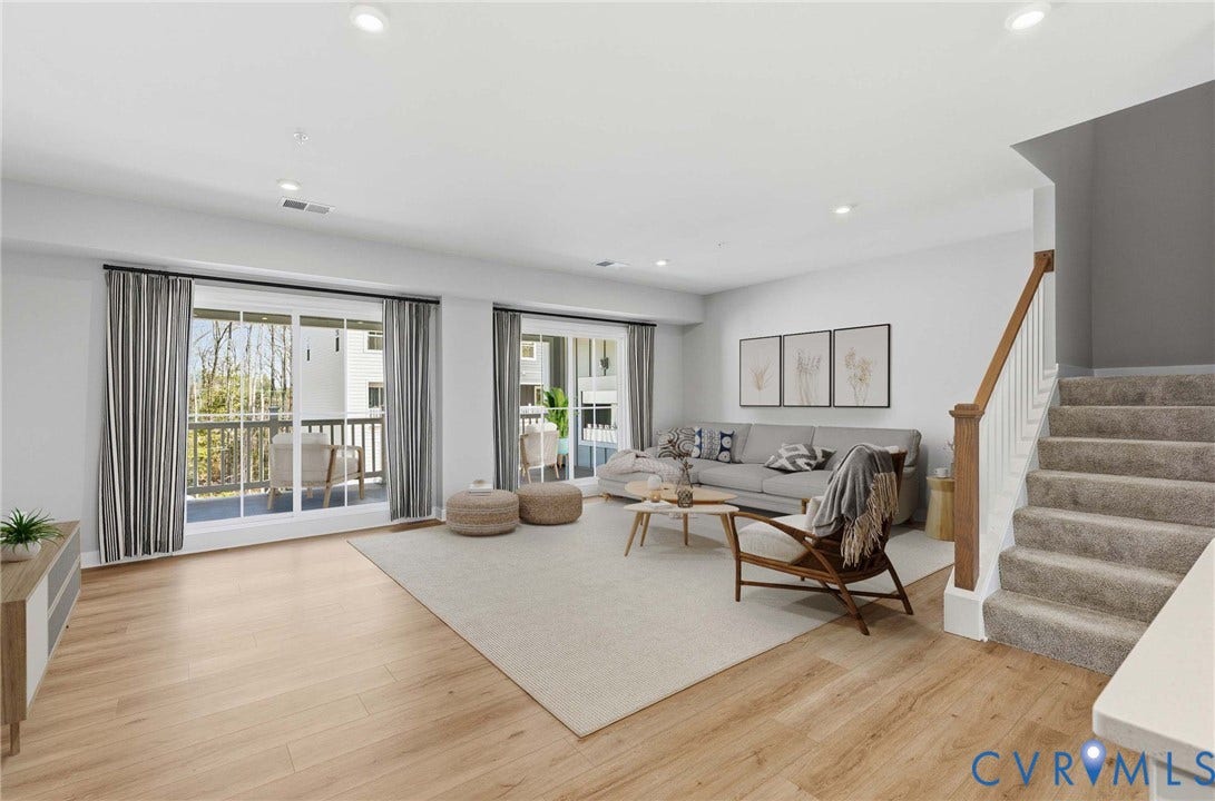Virtual staging. Spacious living area featuring wood-finish flooring, two sets of sliding glass doors, and recessed lighting