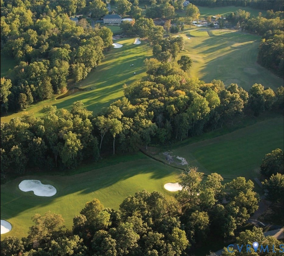 Expansive golf course setting featuring manicured greens, sand bunkers, and mature trees