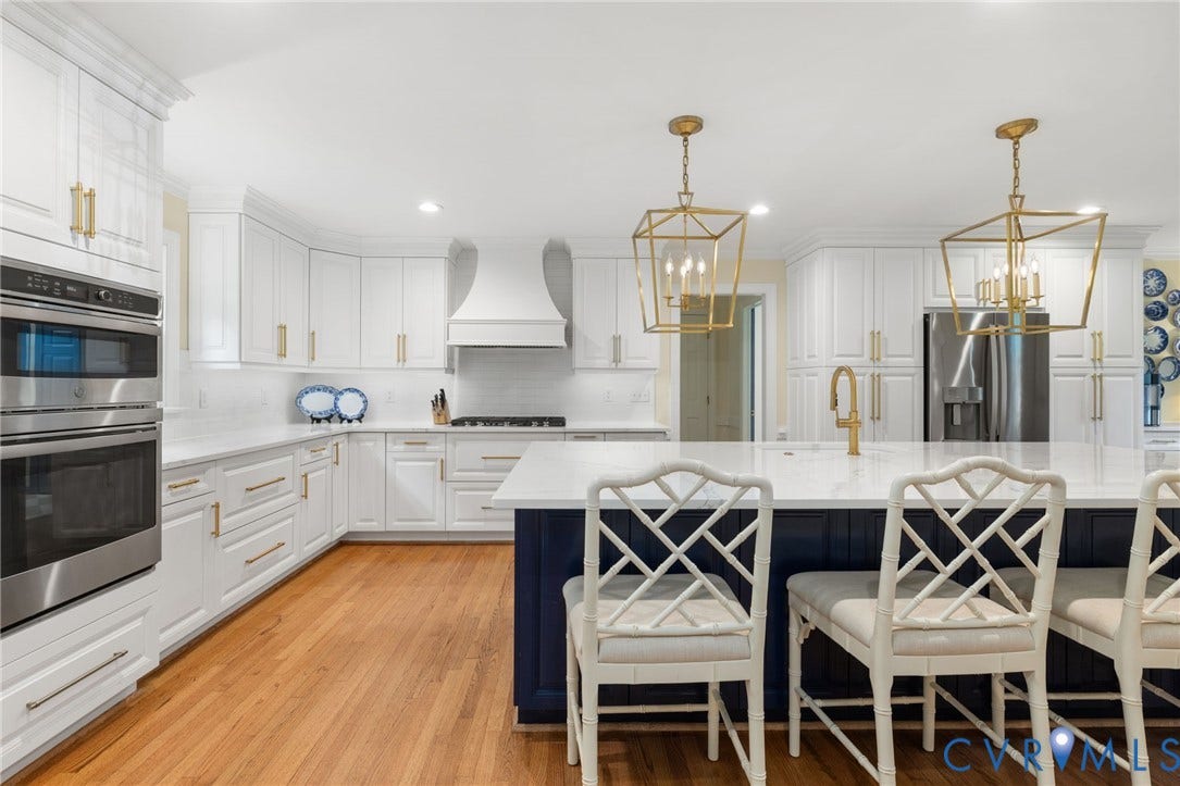 14411 Galloway Court, Salisbury, Midlothian, VA 23113 Spacious kitchen featuring an island with seating, white cabinetry, integrated stainless steel appliances, and wood-finish flooring