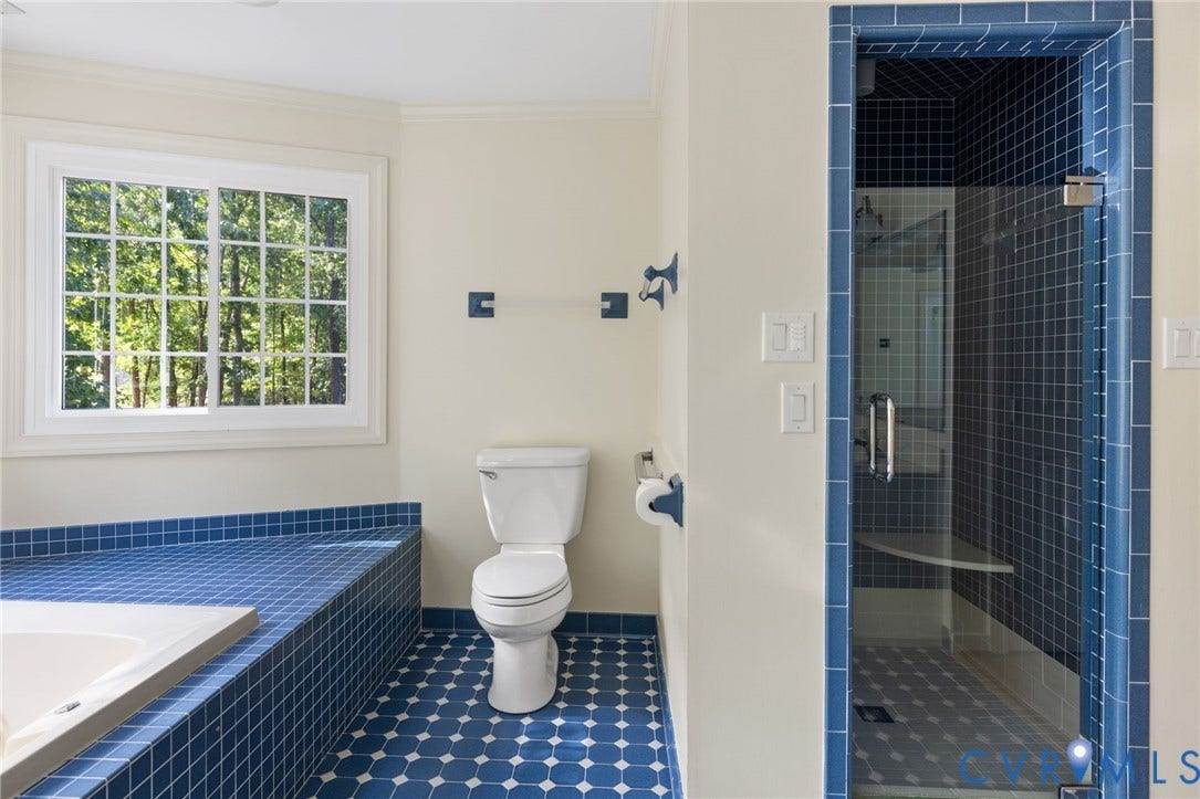 14411 Galloway Court, Salisbury, Midlothian, VA 23113 Bathroom with blue floor tiling, white window with grid panes, white toilet, tiled tub surround, and a glass-enclosed shower with blue tiling