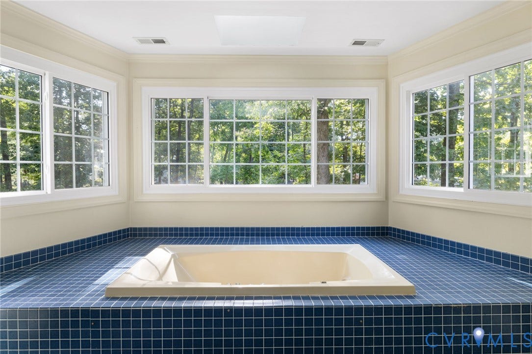 14411 Galloway Court, Salisbury, Midlothian, VA 23113 Recessed soaking tub set in a blue mosaic tile surround, surrounded by multiple grid-pattern windows