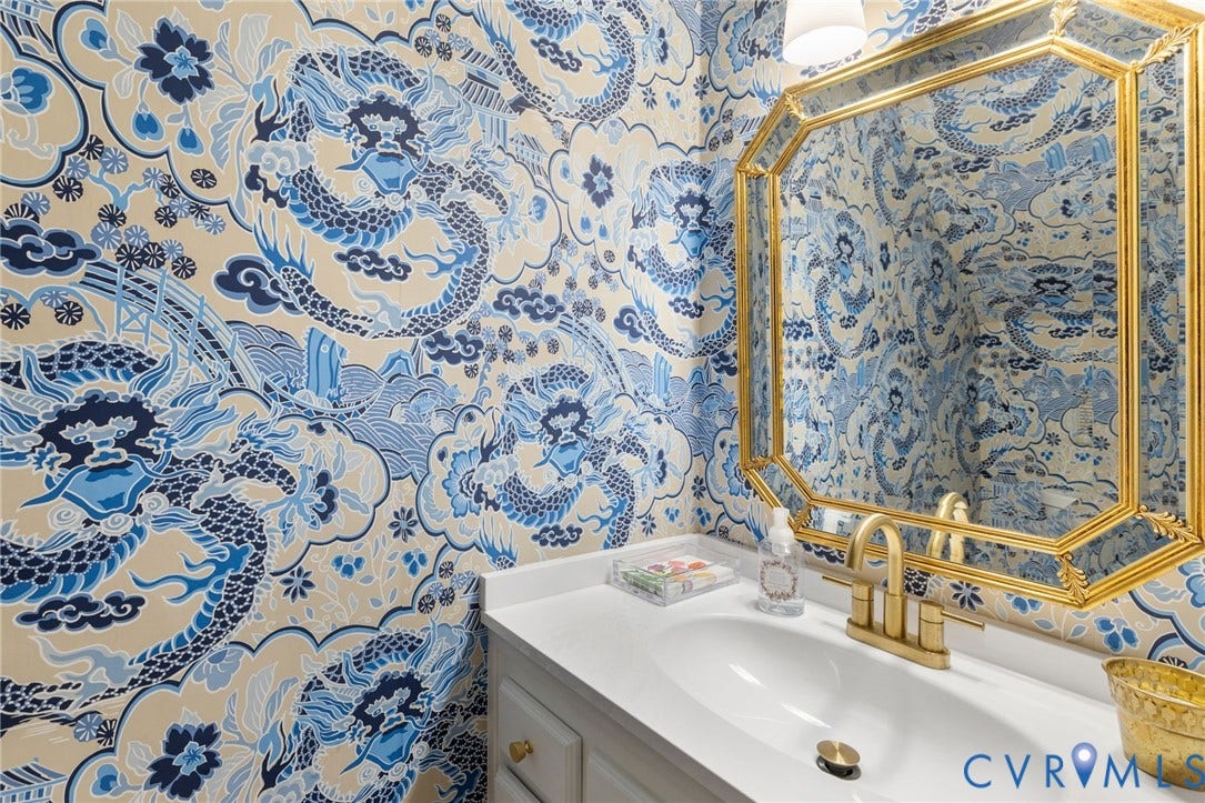 14411 Galloway Court, Salisbury, Midlothian, VA 23113 Powder room featuring decorative wallcovering, octagonal gold-framed mirror, white vanity with integrated sink, and brass-finish faucet