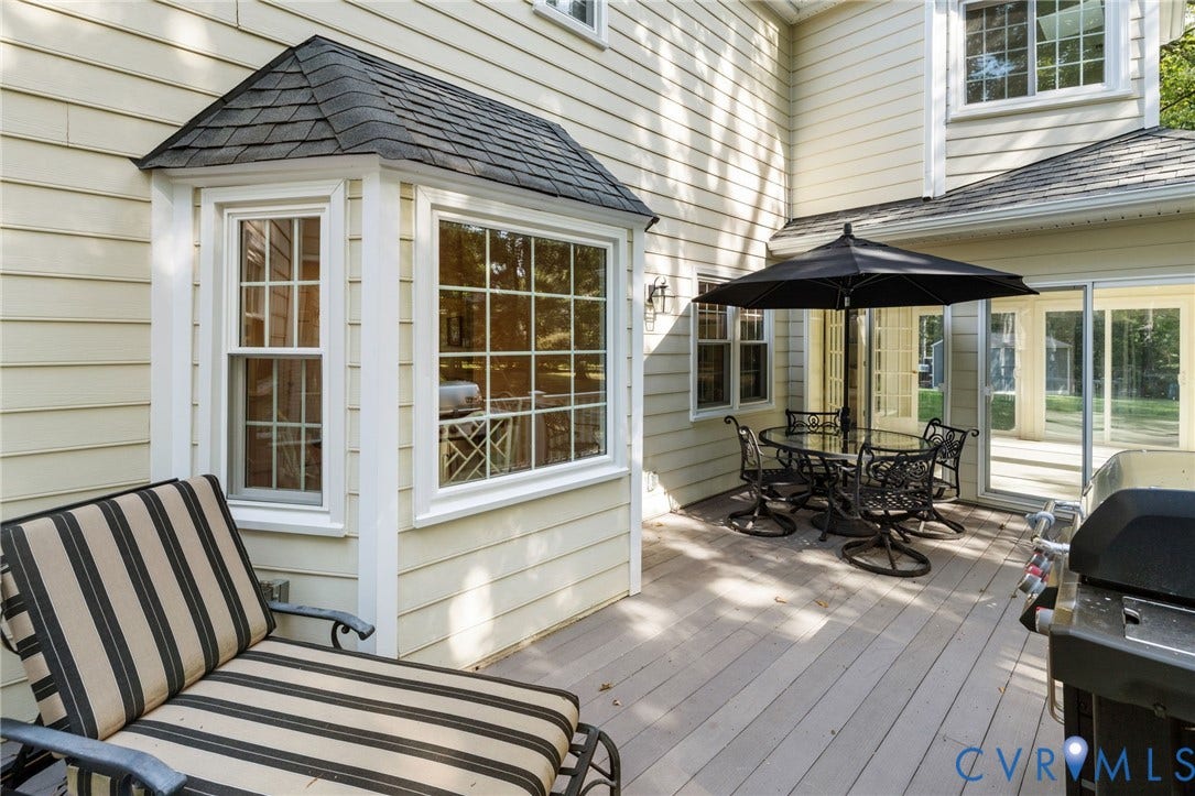 14411 Galloway Court, Salisbury, Midlothian, VA 23113 Exterior deck area featuring a bay window with gridded panes, cream-colored siding, and sliding glass doors