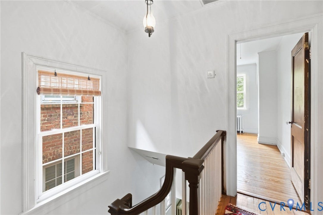 2415 Maplewood Avenue, Byrd Park, Richmond, VA 23220 Hardwood flooring throughout, white painted walls, white trim, and a classic wood baluster with a dark wood handrail