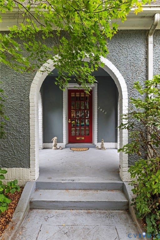2415 Maplewood Avenue, Byrd Park, Richmond, VA 23220 Arched entryway with brick surround, textured exterior finish, and a red paneled door