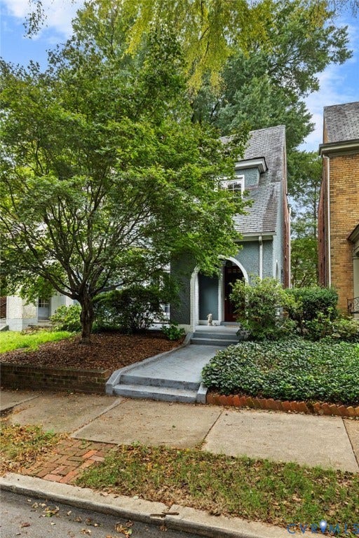 2415 Maplewood Avenue, Byrd Park, Richmond, VA 23220 Stucco exterior with an arched entryway, dormer window, and mature landscaping