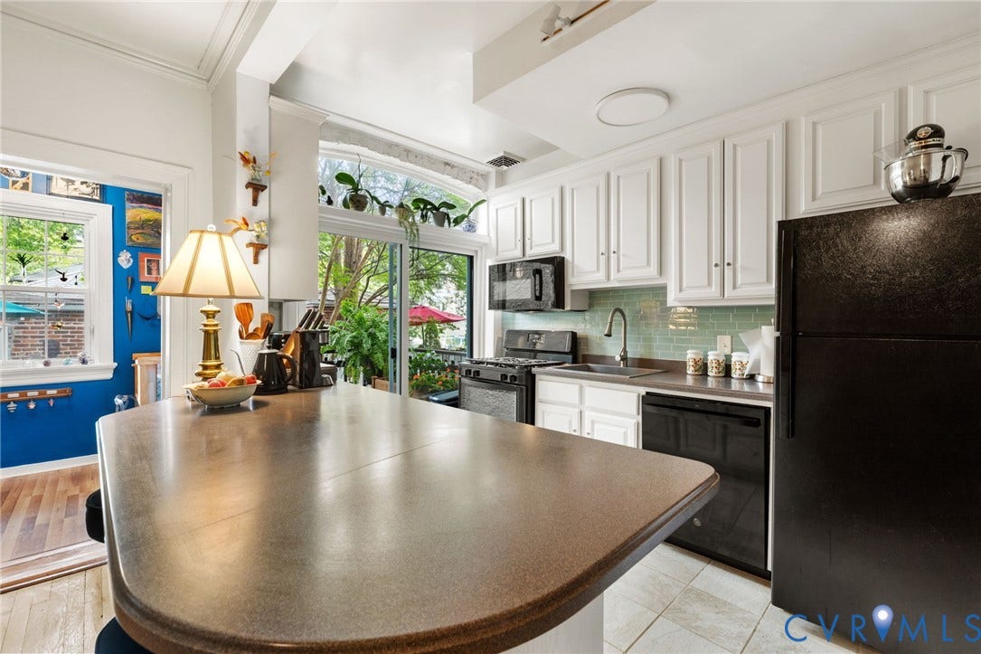 2415 Maplewood Avenue, Byrd Park, Richmond, VA 23220 Kitchen featuring a kitchen island, white cabinetry, black appliances, a tile backsplash, and sliding glass doors