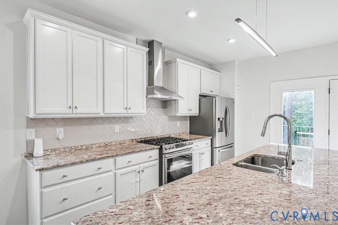 1141 Broad Hill Trace, Saunders Station Townes, Henrico, VA 23233 White cabinetry with crown molding, stainless steel appliances, herringbone tile backsplash, and a large sink with a gooseneck faucet