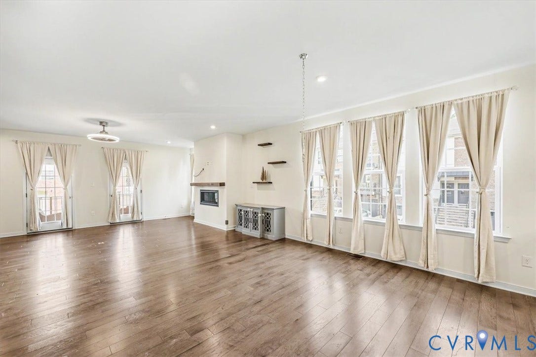 1141 Broad Hill Trace, Saunders Station Townes, Henrico, VA 23233 Expansive room with wood-finish flooring, multiple windows, a modern fireplace, recessed lighting, and a contemporary ceiling fixture