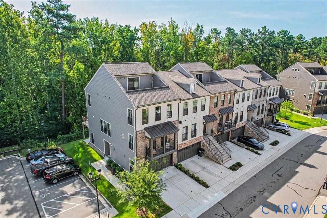 1141 Broad Hill Trace, Saunders Station Townes, Henrico, VA 23233 Townhome architecture featuring multiple dormers, attached garages, private balconies, and a paved parking area