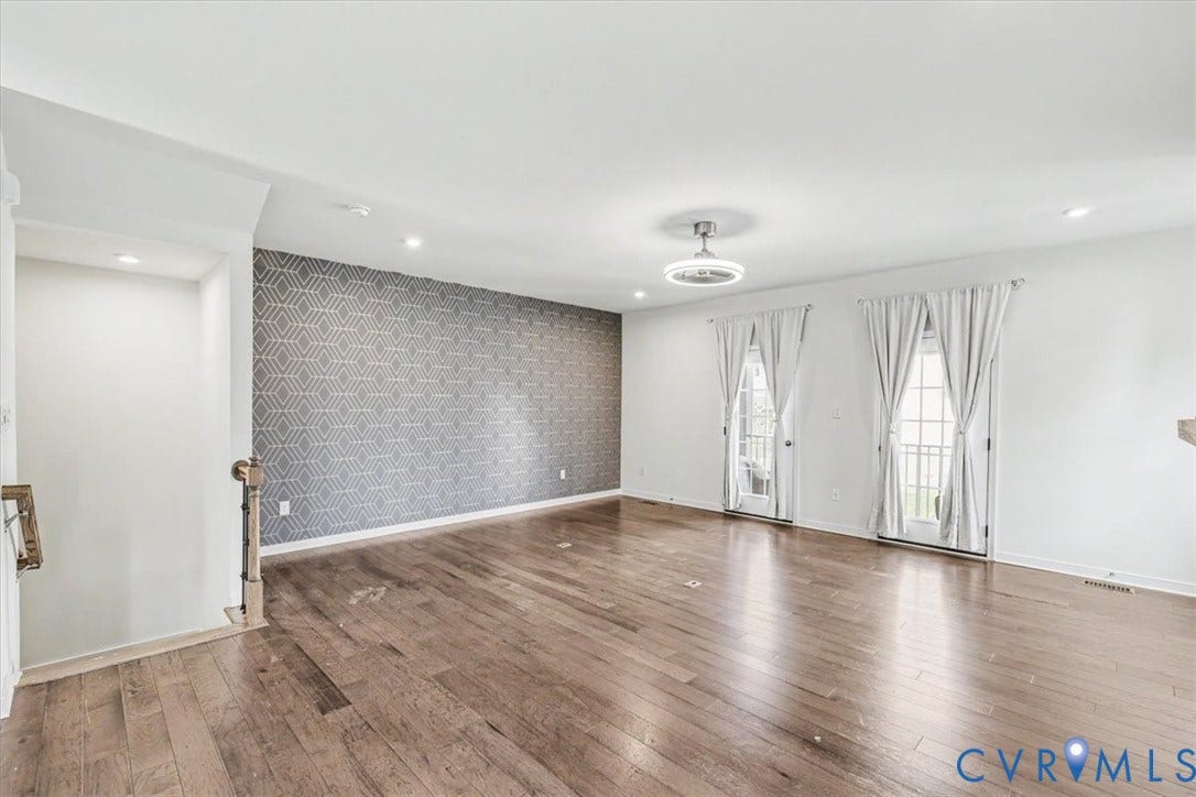 1141 Broad Hill Trace, Saunders Station Townes, Henrico, VA 23233 Hardwood flooring, accent wall with geometric pattern, recessed lighting, and two sets of French doors with transom windows