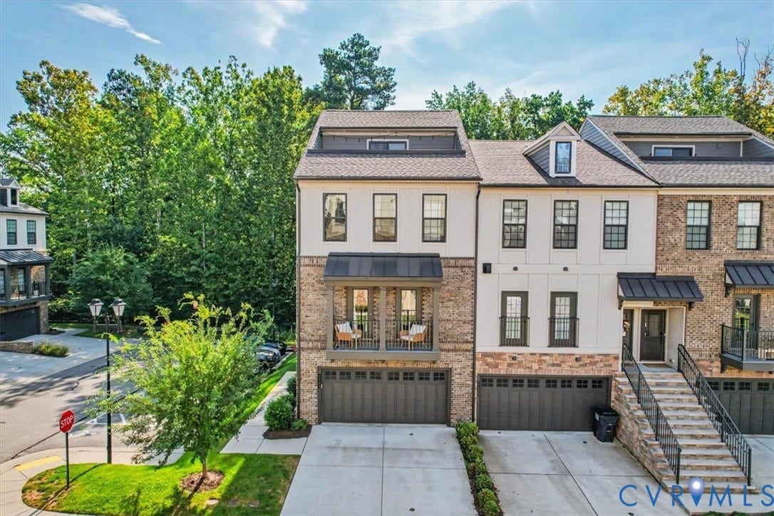 1141 Broad Hill Trace, Saunders Station Townes, Henrico, VA 23233 Multi-level townhome featuring a brick and siding exterior, multiple dormer windows, and attached garages