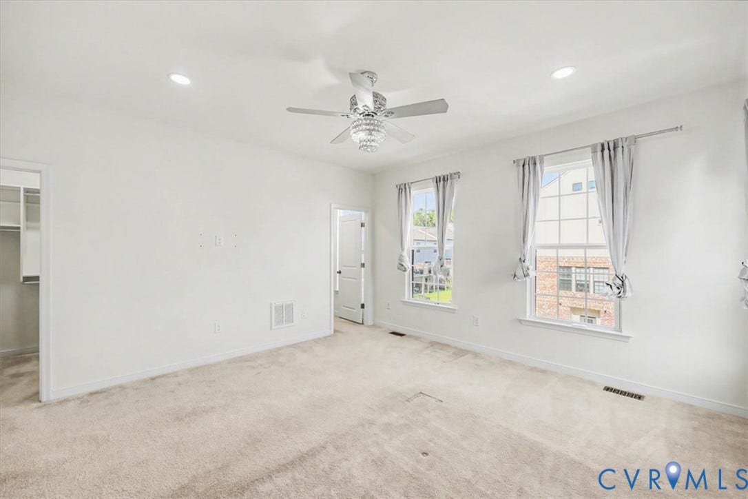 1141 Broad Hill Trace, Saunders Station Townes, Henrico, VA 23233 Recessed lighting, ceiling fan with chandelier-style light fixture, carpeted flooring, two large windows, and a walk-in closet with built-in shelving