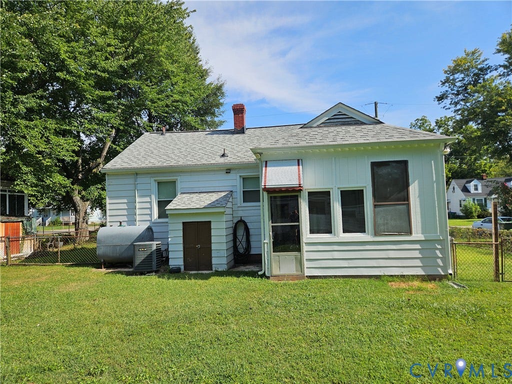 White horizontal siding exterior with multiple windows and an attached utility structure