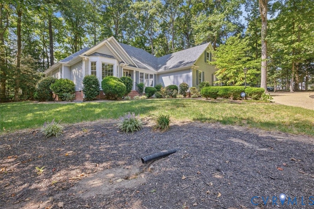Siding exterior with a bay window, mature trees, and established landscaping