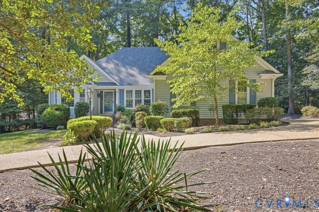 Light-colored siding exterior with a dark-shingled roof and light blue shutters