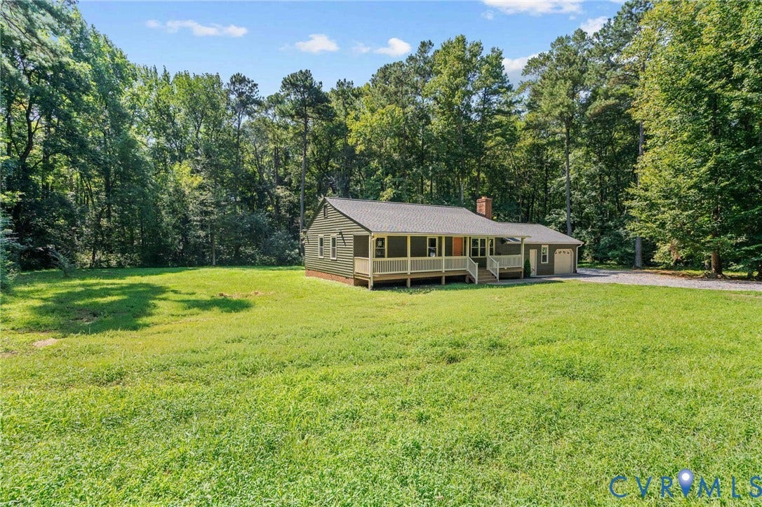 Ranch-style residence featuring a covered front porch, attached garage, and a brick chimney