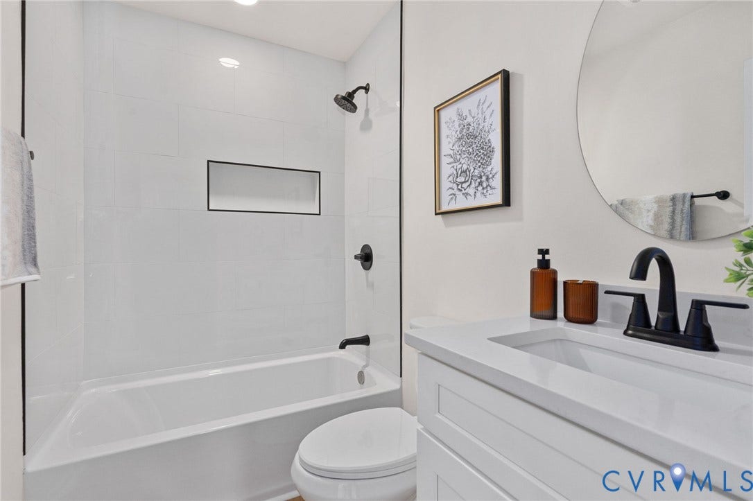 White subway tile tub surround with an integrated black-framed niche