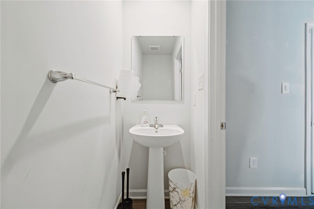 5713 Bison Ford Court, Chesterfield, VA 23234 Pedestal sink, rectangular wall mirror, chrome towel bar, and wood-finish flooring