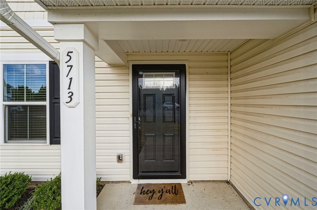 5713 Bison Ford Court, Chesterfield, VA 23234 Covered entry featuring a dark-paneled door with glass insert, light-colored siding, and a window with dark shutters