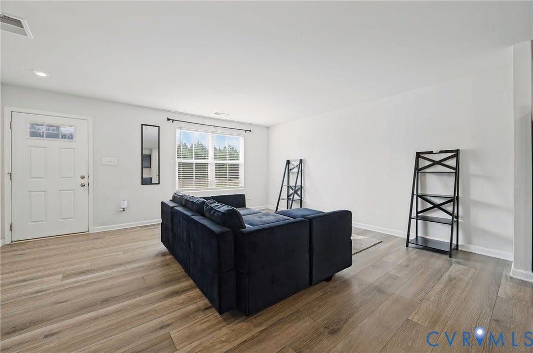 5713 Bison Ford Court, Chesterfield, VA 23234 Spacious living area featuring wood-finish flooring, recessed lighting, and large windows with horizontal blinds
