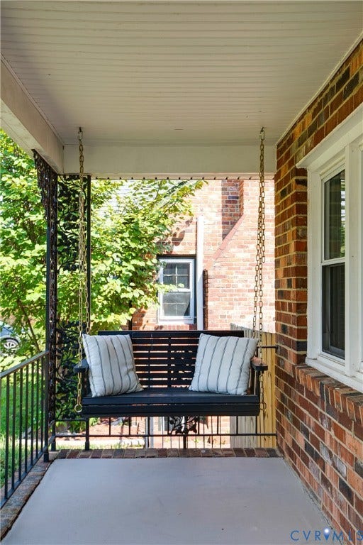 2203 Wedgewood Avenue, Henrico, VA 23228 Covered front porch with brick exterior, white window trim, and black wrought iron railings