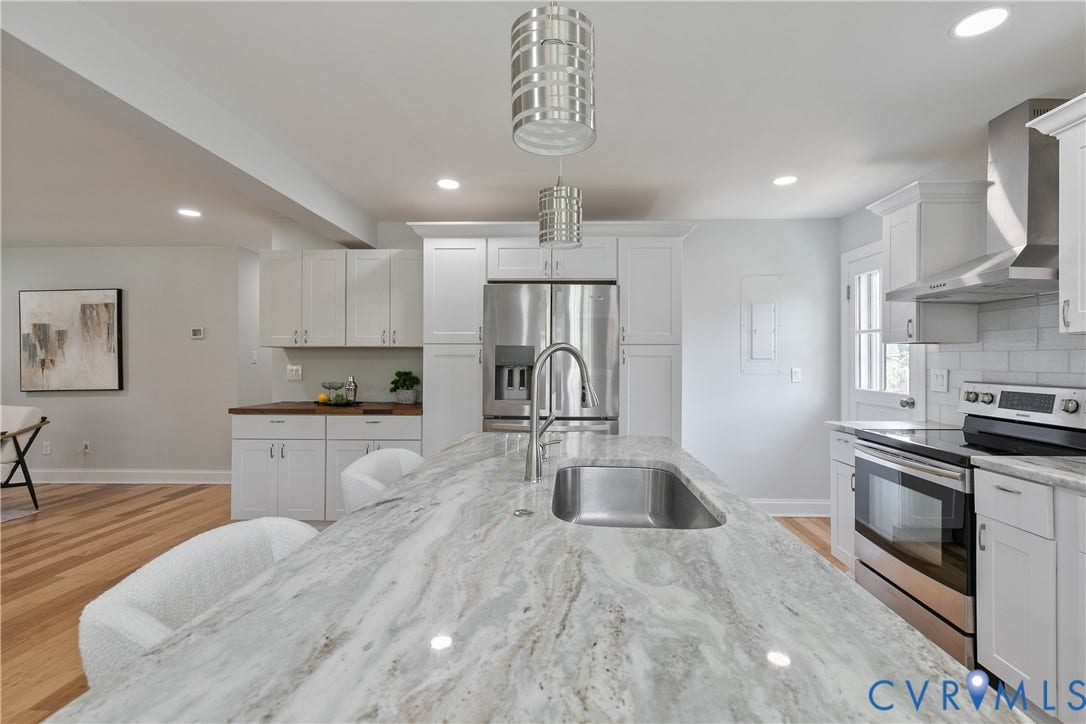 2203 Wedgewood Avenue, Henrico, VA 23228 Kitchen featuring a large island with an undermount sink, stainless steel appliances, white cabinetry, and wood-finish flooring
