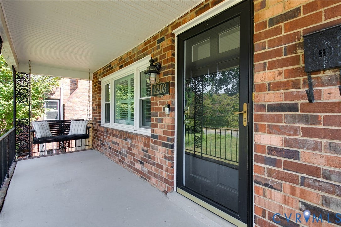 2203 Wedgewood Avenue, Henrico, VA 23228 Brick exterior with white trim, covered front porch, beadboard porch ceiling, and a black storm door with brass hardware