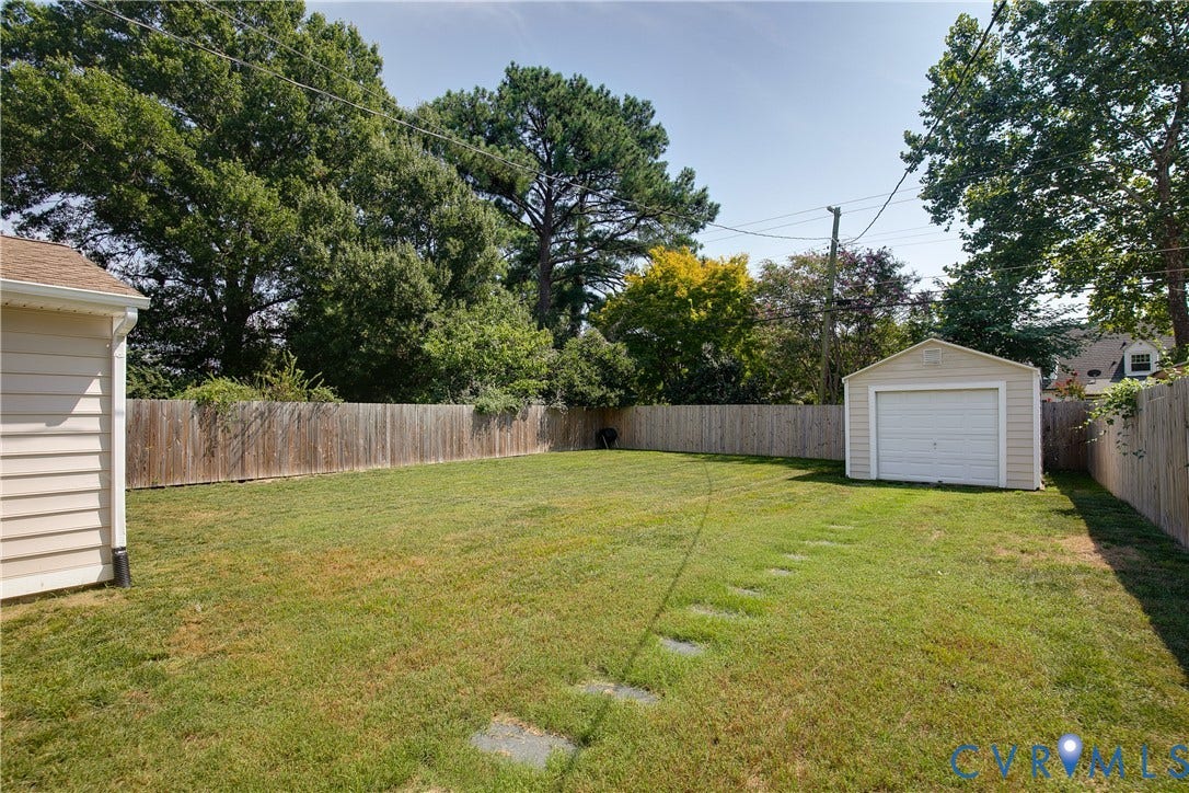 2203 Wedgewood Avenue, Henrico, VA 23228 Expansive grassy yard with a wood privacy fence and a detached garage