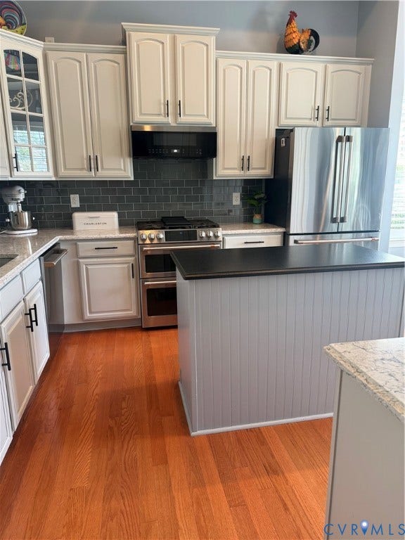 3345 Manor Grove Circle, Glen Allen, VA 23059 Kitchen featuring light cabinetry, stainless steel appliances, grey subway tile backsplash, and wood-finish flooring