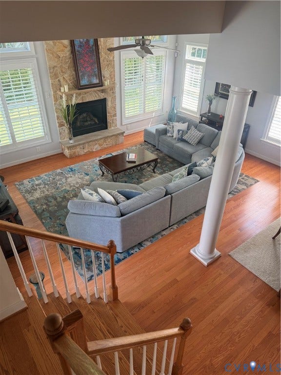 3345 Manor Grove Circle, Glen Allen, VA 23059 Vaulted ceiling with a stone fireplace, wood-finish flooring, and multiple windows with plantation shutters