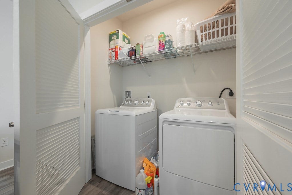 4000 Maze Runner Drive, #101, Midlothian, VA 23112 Laundry closet featuring a built-in wire shelf, louvered bi-fold doors, and wood-finish flooring