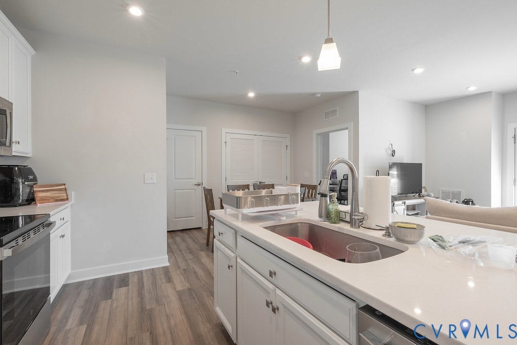 4000 Maze Runner Drive, #101, Midlothian, VA 23112 Kitchen featuring white cabinetry, stainless steel appliances, wood-finish flooring, recessed lighting, and an island with an integrated sink and gooseneck faucet