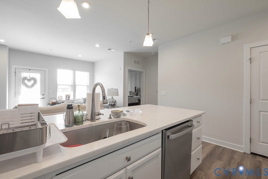 4000 Maze Runner Drive, #101, Midlothian, VA 23112 Kitchen island with an undermount sink, gooseneck faucet, and integrated stainless steel dishwasher