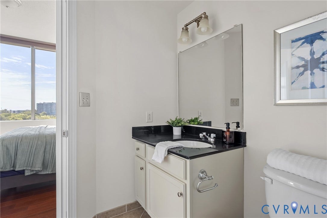 1101 Haxall Point, #U514, Richmond, VA 23219 Vanity with dark countertop, white under-mount sink, and dual light fixture