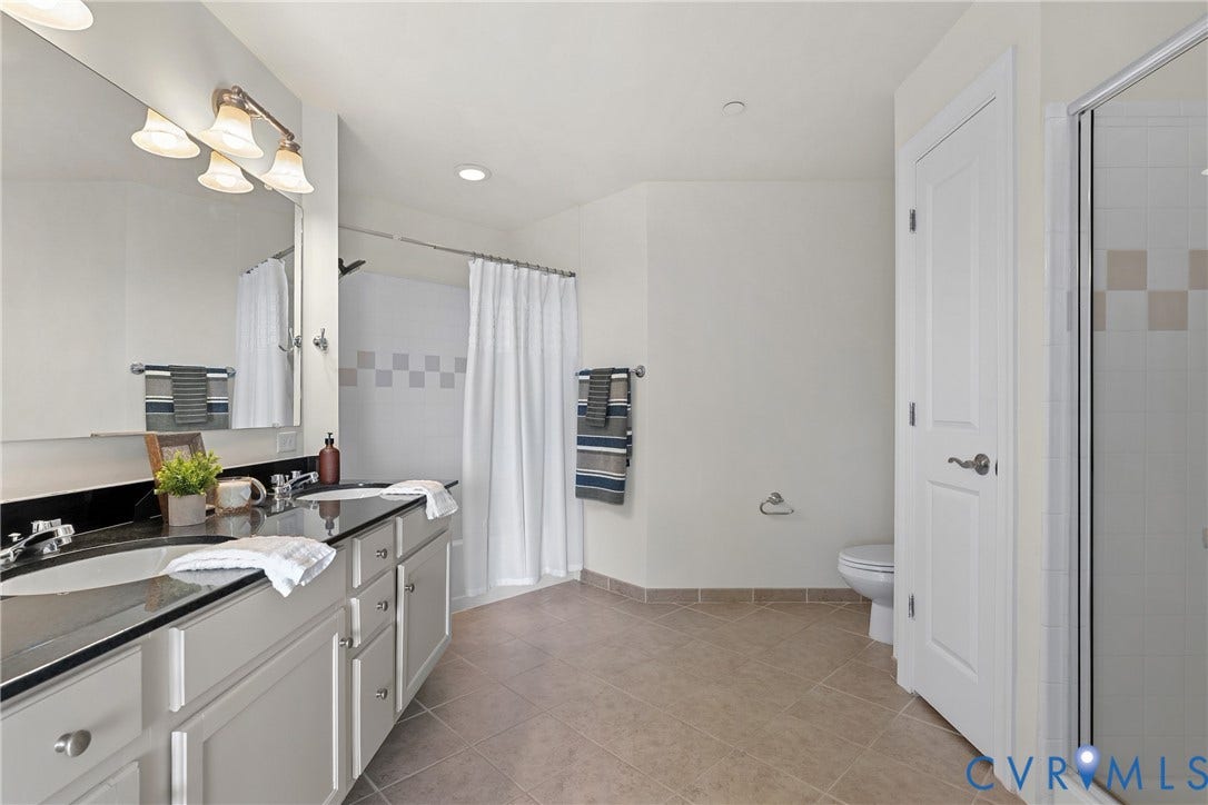 1101 Haxall Point, #U514, Richmond, VA 23219 Dual vanity with integrated sinks and dark countertop, large mirror, recessed lighting, and a separate shower enclosure