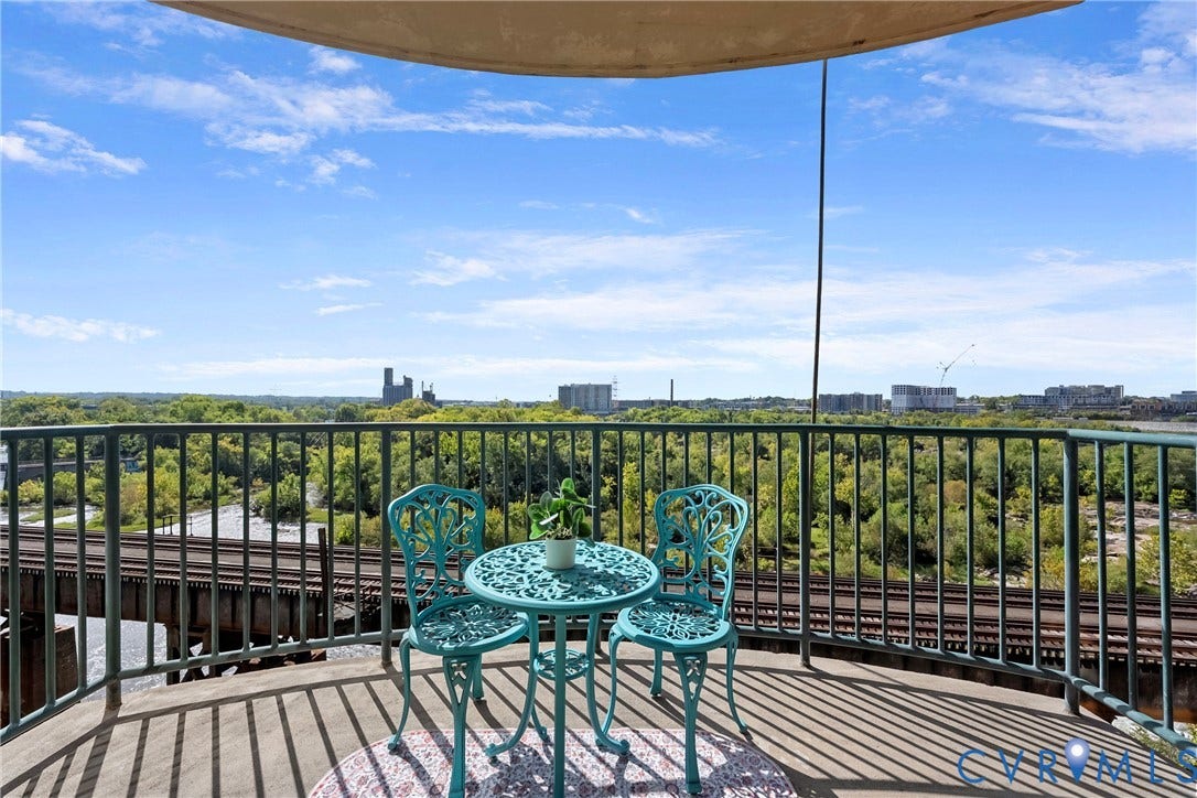 1101 Haxall Point, #U514, Richmond, VA 23219 Curved balcony featuring a metal railing, concrete flooring, and distant urban skyline