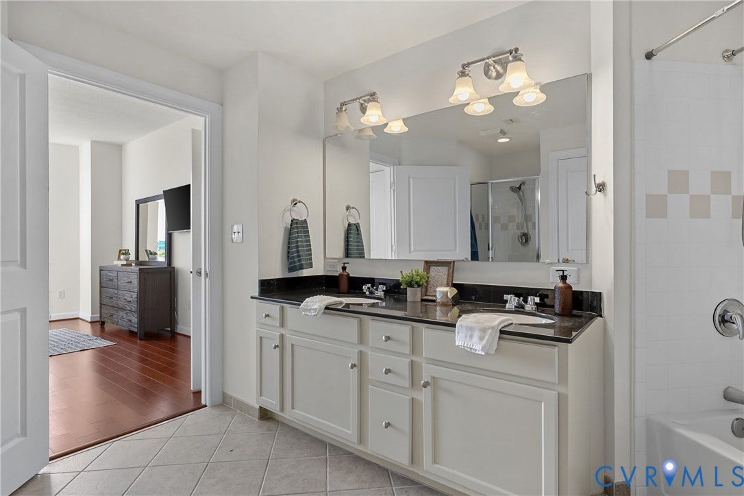 1101 Haxall Point, #U514, Richmond, VA 23219 Dual vanity with dark stone countertop, undermount sinks, and white cabinetry