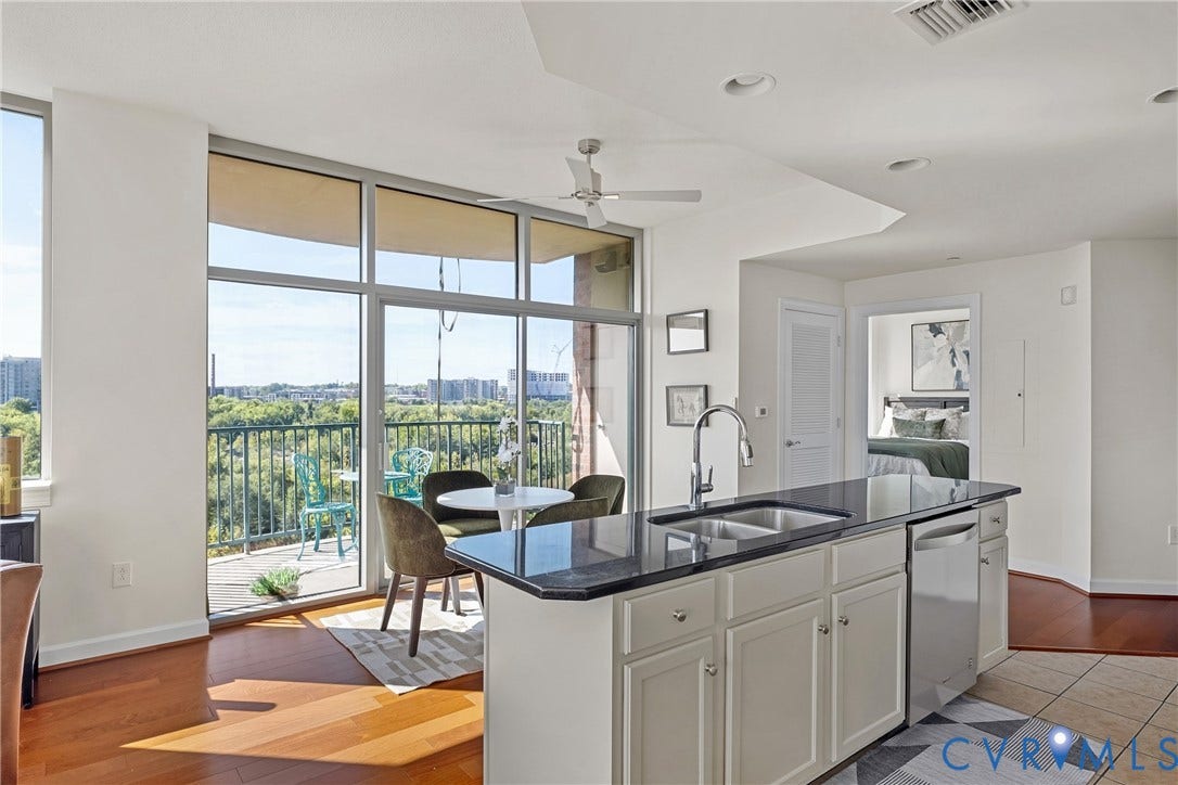1101 Haxall Point, #U514, Richmond, VA 23219 Floor-to-ceiling glass doors opening to a balcony, kitchen island with dark countertop and stainless steel sink, hardwood flooring, recessed lighting, and a ceiling fan