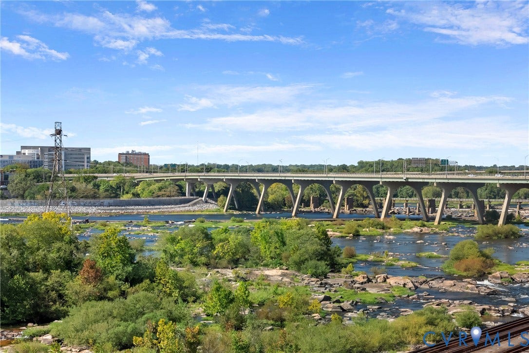1101 Haxall Point, #U514, Richmond, VA 23219 Riverfront setting featuring a bridge, surrounding greenery, and urban structures in the background