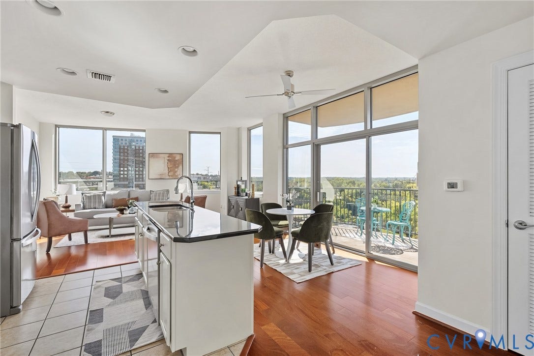 1101 Haxall Point, #U514, Richmond, VA 23219 Open-concept living space with expansive windows, wood-finish flooring, a kitchen island with stone countertops, and direct access to an outdoor balcony