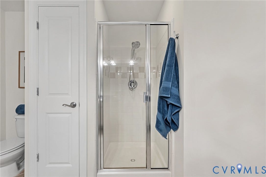 1101 Haxall Point, #U514, Richmond, VA 23219 Glass-enclosed shower with a tiled surround, chrome shower fixtures, and integrated lighting