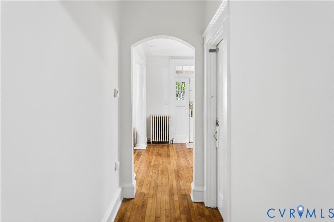 1304 Bainbridge Street, Manchester, Richmond, VA 23224 Wood-finish flooring with a white archway leading to an entry door