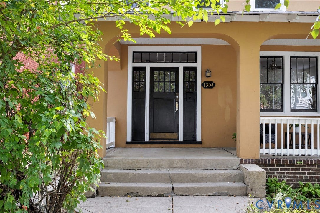 1304 Bainbridge Street, Manchester, Richmond, VA 23224 Covered entry porch featuring an arched opening, paneled front door with transom and sidelights, and a white balustrade