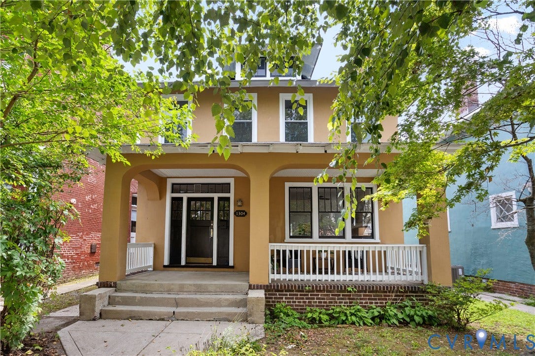 1304 Bainbridge Street, Manchester, Richmond, VA 23224 Two-story stucco exterior with a covered porch, white railing, and concrete steps