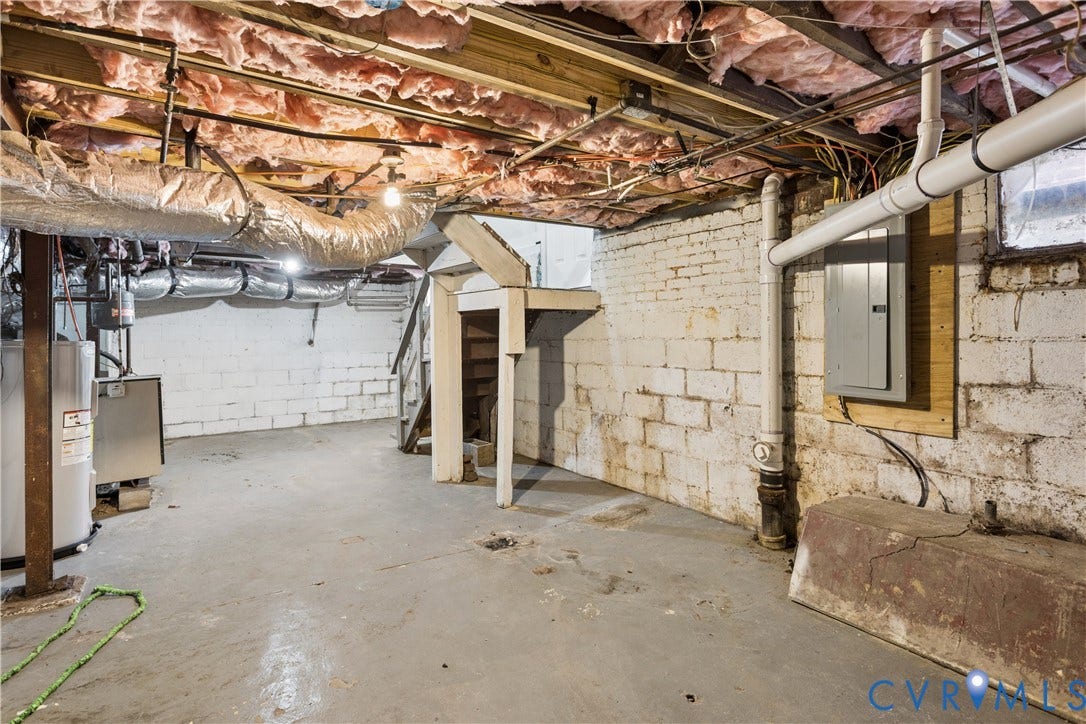 1304 Bainbridge Street, Manchester, Richmond, VA 23224 Concrete flooring, exposed wood ceiling joists, white cinder block walls, exposed ductwork, and an electrical panel