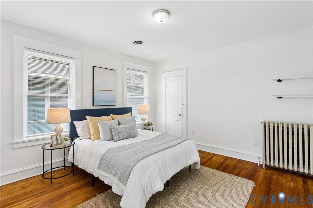 1304 Bainbridge Street, Manchester, Richmond, VA 23224 Hardwood flooring, painted white walls, two windows, built-in shelving, and a white interior door