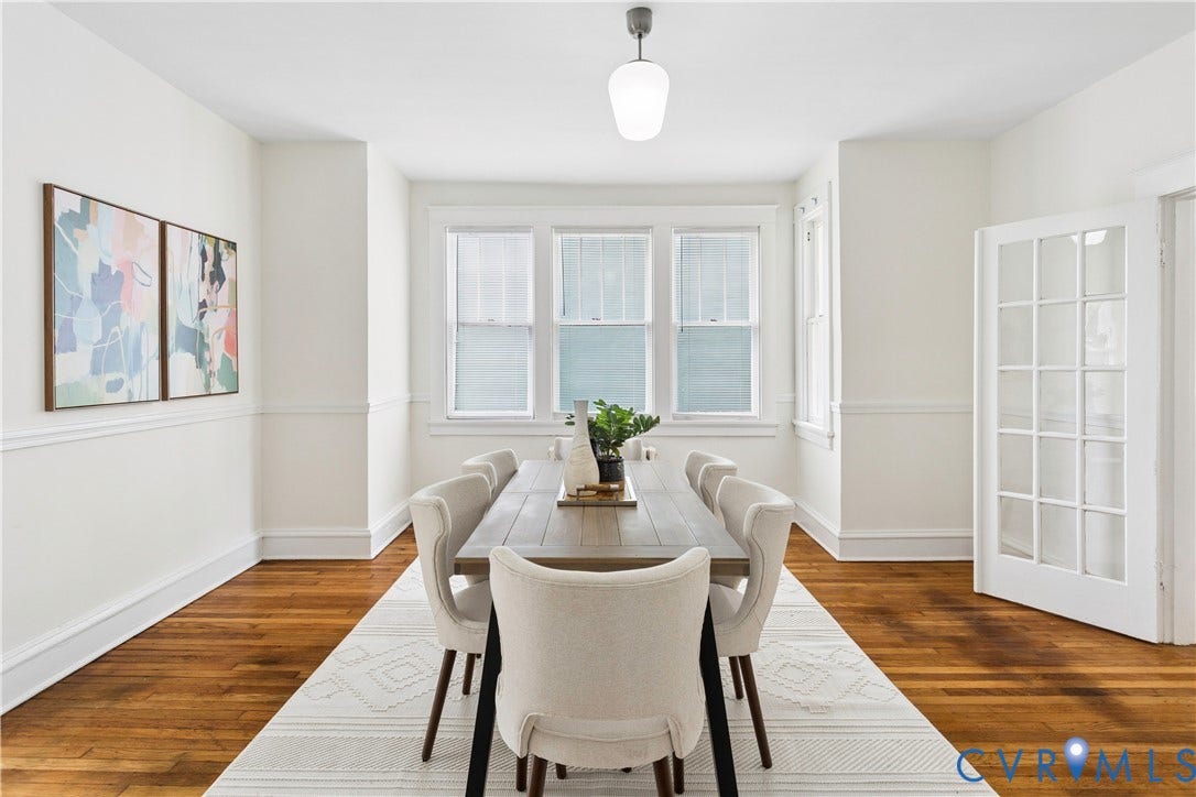 1304 Bainbridge Street, Manchester, Richmond, VA 23224 Hardwood flooring, white wainscoting, three large windows, white French door, and a suspended white glass pendant light