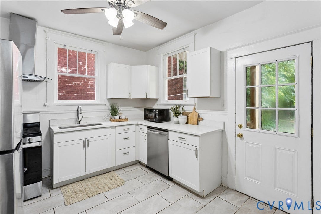 1304 Bainbridge Street, Manchester, Richmond, VA 23224 White shaker cabinetry, stainless steel sink, tile flooring, stainless steel appliances, and a ceiling fan with light fixture