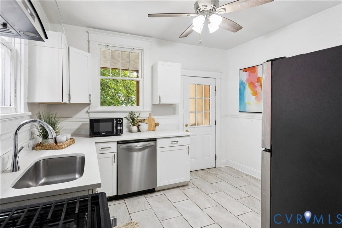 1304 Bainbridge Street, Manchester, Richmond, VA 23224 White cabinetry with stainless steel appliances, white countertops, and light-toned tile flooring